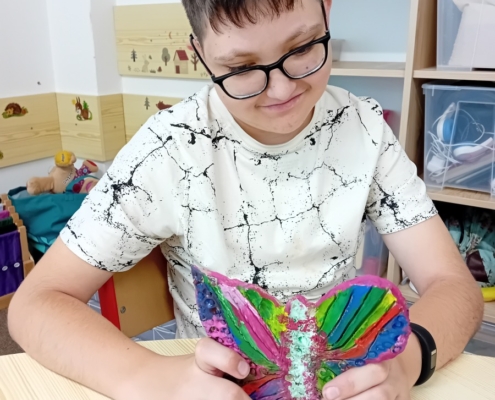 V keramice děti domalovaly barvami výrobky- šneky a motýla